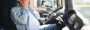 Exhausted truck driver falling asleep on steering wheel. Tiredness and sleeping concept.