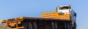 Yellow flatbed truck on open road